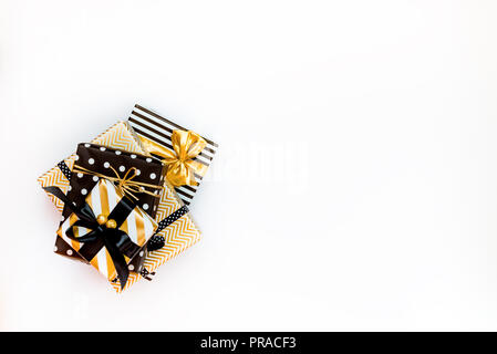 Top view of a heap of gift boxes in various black, white and golden designs. A concept of Christmas, New Year, birthday celebration event. Stock Photo