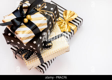 Top view of a heap of gift boxes in various black, white and golden designs. A concept of Christmas, New Year, birthday celebration event. Stock Photo