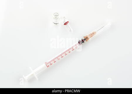 Ampoule with medicine and syringe on white background. Stock Photo