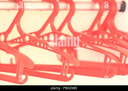 Red plastic hangers in an empty wardrobe Stock Photo