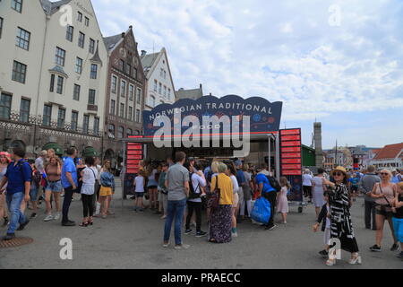 People queue at a food stall selling traditional Norwegian food on the Hanseatic wharf in Bergen city centre, Norway. Stock Photo