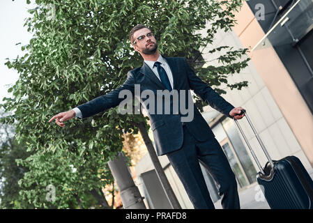 Businessman trying to catch a taxi in business cuty district Stock Photo