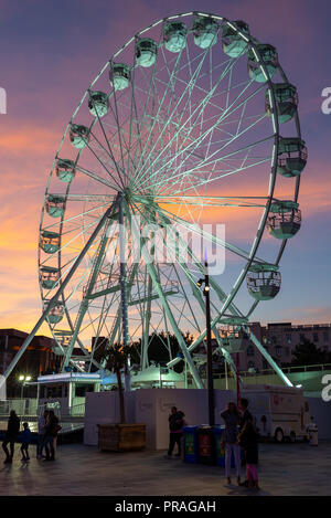 Fairground Ferris Wheel at Pier Approach, Bournemouth, Dorset, UK under a pink and blue sunset sky. Stock Photo