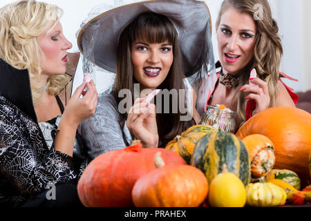 Best friends sharing candies while celebrating Halloween Stock Photo