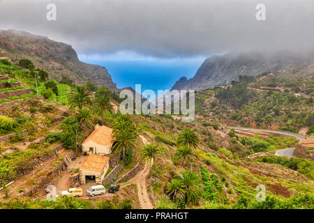 LA GOMERA, SPAIN - AUGUST 18: (EDITORS NOTE: Image is a digital [High Dynamic Range, HDR] composite.) The San Barranco de las Rosas valley is seen on August 18, 2018 in La Gomera, Spain. The valleys of the island are often covered by clouds in summer too. Stock Photo