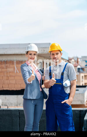 Architect and Construction worker on site giving thumbs-up Stock Photo