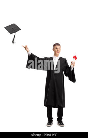 Portrait of graduate teen latin boy student in black graduation gown with  hat, holding diploma - isolated on background. Child back to school and  educational concept. Stock Photo