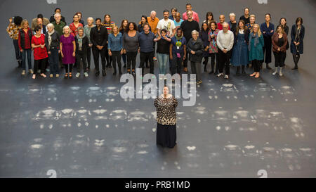 London, UK. 1st Oct, 2018. Tania Bruguera (front) stands with volunteers after leaving body impressions on the heat-sensitive floor. Unveiling of the this year's Hyundai Commission by Cuban artist and activist Tania Bruguera at Tate Modern. The work is called 'an ever-increasing figure', which represents the scale of mass migration and the risks involved. Visitors are invited to interact with the work which comprises a heat-sensitive floor, which includes a portrait of a person's face beneath, combined with low frequency sounds. The work is on display 2 Oc,  to 24 February 2019. Credit: Stephe Stock Photo
