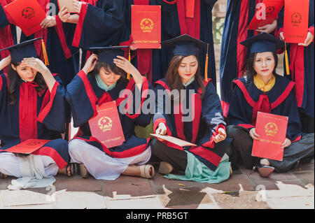 Hanoi, Vietnam - October 16, 2016. Group of students dressed in caps and gowns celebrating their university graduation. Temple of Literature. Stock Photo