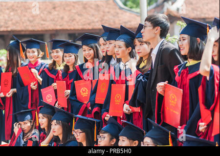 Hanoi, Vietnam - October 16, 2016. Group of students dressed in caps and gowns celebrating their university graduation. Temple of Literature. Stock Photo