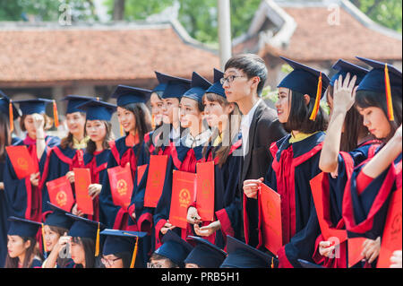 Hanoi, Vietnam - October 16, 2016. Group of students dressed in caps and gowns celebrating their university graduation. Temple of Literature. Stock Photo