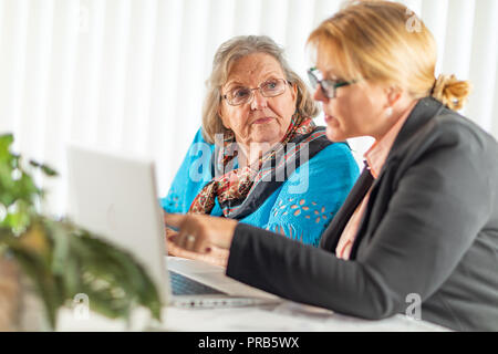 Woman Helping Senior Adult Lady on Laptop Computer. Stock Photo