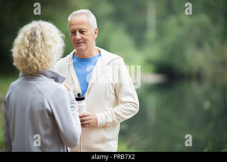 Two senior active people having talk in natural environment after workout Stock Photo