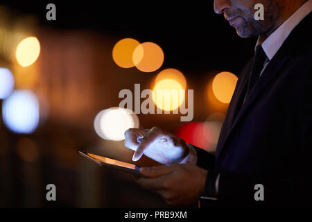 Elegant businessman using tablet for searching online information or reading news in the net Stock Photo