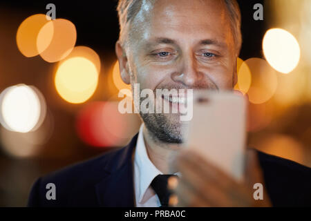 Smiling businessman looking at camera of smartphone while posing for selfie Stock Photo