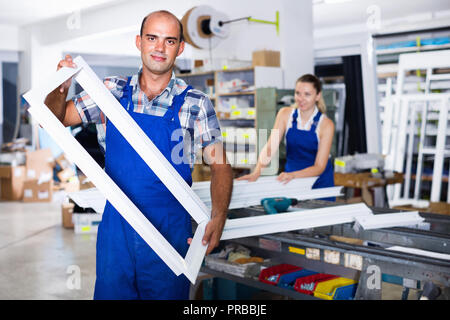 diligent foreman demonstrating window frame in factory Stock Photo - Alamy