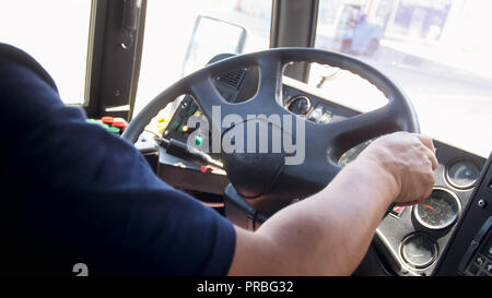 Closeup image of bus driver hands holding steering wheel Stock Photo