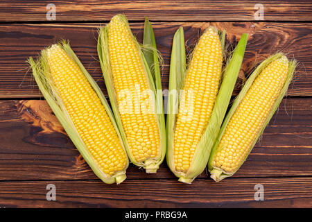 Corn cobs on wooden table. Stock Photo