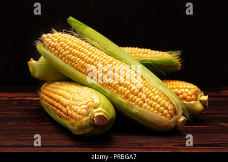 Corn cobs on wooden table. Stock Photo
