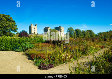 Helmsley Castle overlooking the Helmsley Walled Garden with a show of autumn flowers Stock Photo