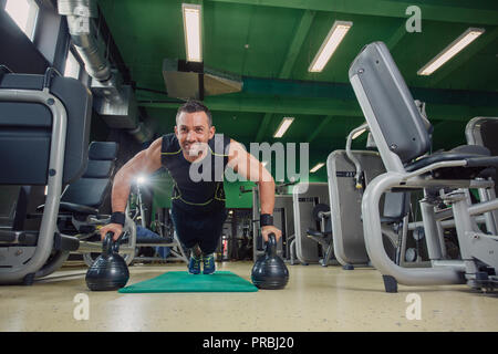 Man doing pushups in the gym on the floor Stock Photo