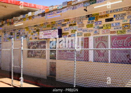 The disused Menzies roadhouse is decorated with number plates and is serviced by 24 hour automatic fuel pumps, Menzies Western Australia Stock Photo