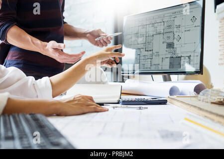 professional architect designer structural engineer team colleagues working office looking computer discussing building plan design project Stock Photo
