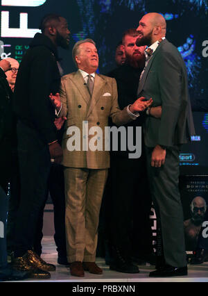 Deontay Wilder (left) and Tyson Fury (right) react as promoter Frank Warren (centre) keeps them apart during a press conference at BT sport Studio, London. PRESS ASSOCIATION Photo. Picture date: Monday October 1, 2018. See PA story BOXING Fury. Photo credit should read: Steven Paston/PA Wire. Stock Photo