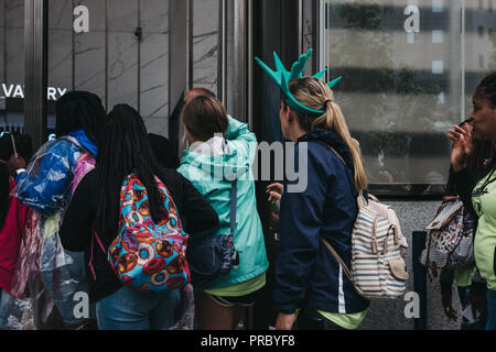 New York, USA - May 31, 2018: Woman wearing Statue of Liberty crown entering One World Observatory. Statue of Liberty and One World Observatory are on Stock Photo