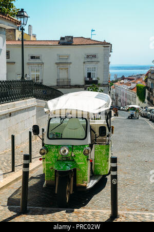 Lisbon, Portugal - Sept 23, 2018: Green Tuk-Tuk Urban Vehicle for Tourists Transportation parked at the historic Se district of Lisbon, Portugal Stock Photo