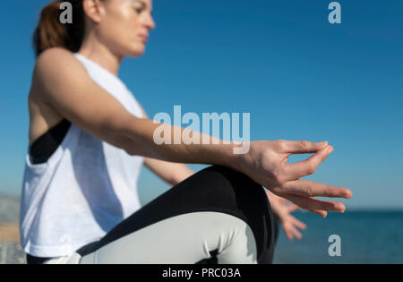 Woman meditating, practicing yoga by the sea. Stock Photo