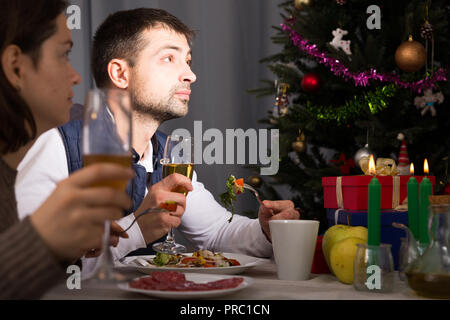 Family couple having christmas dinner with champagne and watching tv Stock Photo