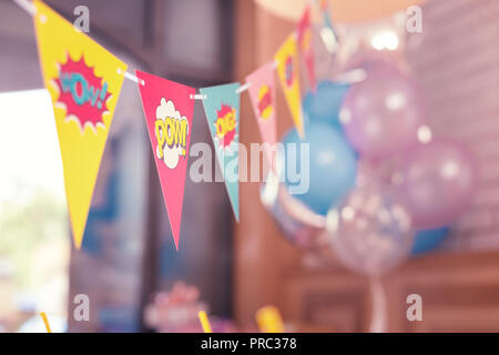Colorful triangle party flags placed in the room before birthday party Stock Photo