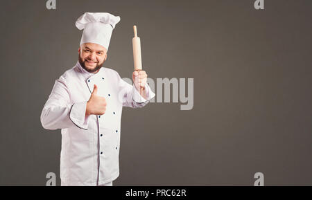 Funny cheerful chef in white uniform on a background. Stock Photo