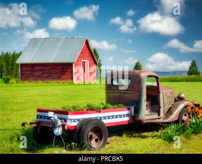 Old truck with flowers and barn. Near flora, Oregon Stock Photo