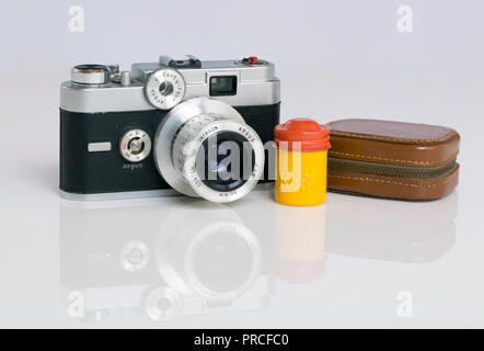 An American made Argus C44R 35mm rangefinder film camera, a Kodak canister color coded for Kodachrome film, and an exposure meter in a leather case. T Stock Photo