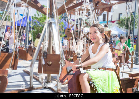 Child girl having fun at Human powered carousel. Motion blurred shot Stock Photo