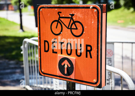 Orange road detour sign for bicycle in French. Arrow pointing straight. Stock Photo