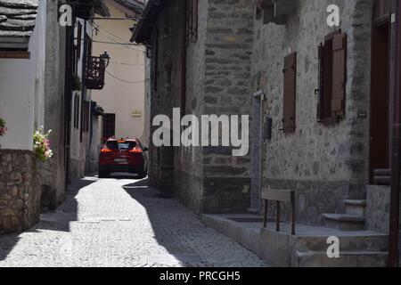 Car traveling through a tiny street in Courmayeur, Italy near the Mont Blanc tunnel Stock Photo