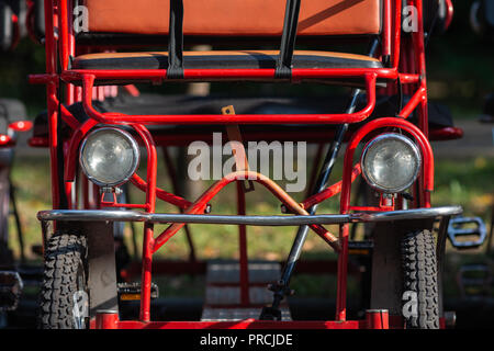 Frontal view of a park family pedal car. Wheels, headlights, metal bars Stock Photo
