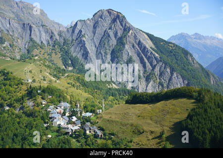 AERIAL VIEW. Small village with a rugged mountain landscape for background. Ornon, Isère, Auvergne-Rhône-Alpes, France. Stock Photo