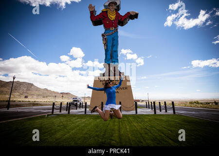 Woman jumps in front of the famous Wendover Will sign in West Wendover Nevada Stock Photo