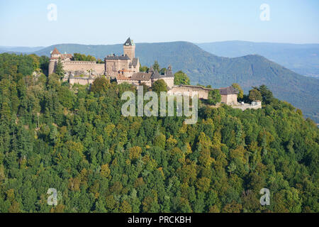 AERIAL VIEW. Pink sandstone medieval castle on a wooded mountain top. Haut-Koenigsbourg Castle, Orschwiller, Bas-Rhin, Alsace, Grand Est, France. Stock Photo