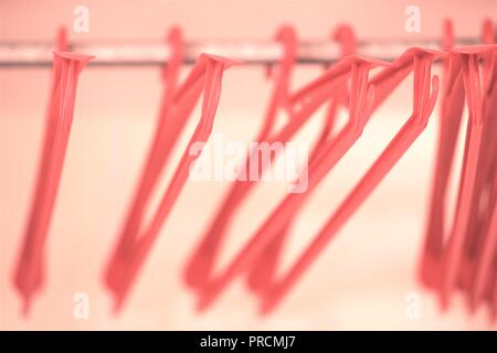 Red plastic hangers in an empty wardrobe. Soft and bokeh Stock Photo