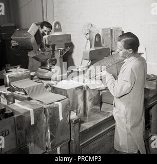 1950s historical, male workers weighing and putting medicines - tablets and pills-  into boxes at the pharmaceutical company of Arthur H. Cox, of Brighton, England, UK. Started in 1839, Cox's of Brighton became a leading British manufacturer and worldwide supplier of medical products and pharmaceutical drugs in tablet, cream and liquid form. Stock Photo