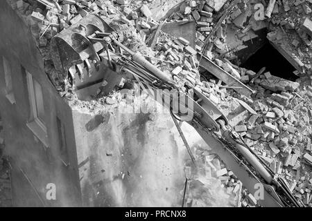 Crushing brick wall, building demolition with an excavator, view from above. Stock Photo