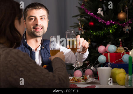 Family couple having christmas dinner with champagne and watching tv Stock Photo