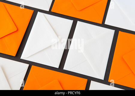Composition with white and orange envelopes on the table. Different colored envelopes on the table. Stock Photo