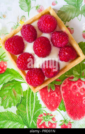 M&S fresh Raspberry Tart set on summery strawberry serviette napkin Stock Photo