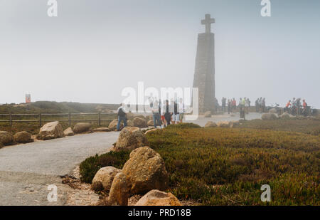 Cabo da Roca, Portugal - Sept 24, 2018: Tourists at a misty Cabo da Roca, a cape which forms the westernmost extent of continental Europe Stock Photo